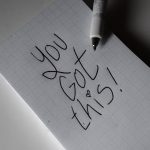 Inspirational handwritten note on graph paper with pen. Encouraging words 'You got this!'